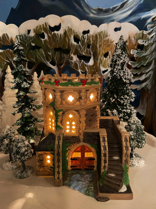 Dept 56 Christmas Village Gunnersbury Park Folly illuminated stone tower with garland and snowy trees on Tampa Home & Garden Store