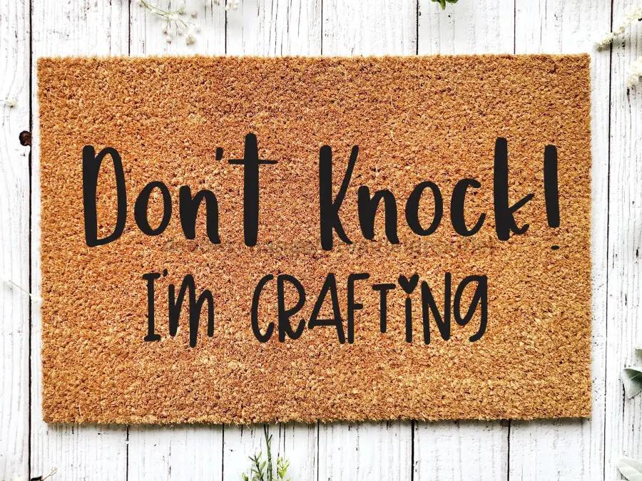 Door mat Don't Knock I'm Crafting slogan in black on natural brown coir for craft room on Tampa Home & Garden Store