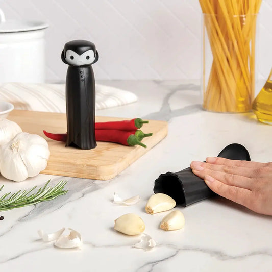Drac N Roll garlic peeler by OTOTO DESIGN, black vampire-shaped kitchen gadget with garlic cloves on Tampa Home & Garden Store