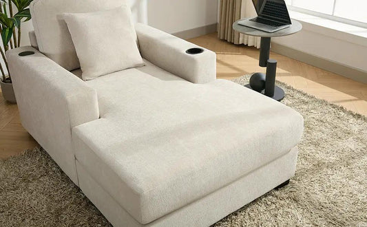 Oversized beige chaise lounge sofa with pillows and armrest cupholders in a bright living room on Tampa Home & Garden Store