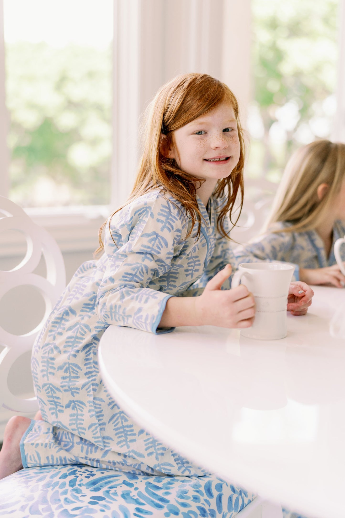 Mini Trellis Pajama blue set with long-sleeve top and pants, red-haired girl at a white table holding a mug on Tampa Home & Garden Store