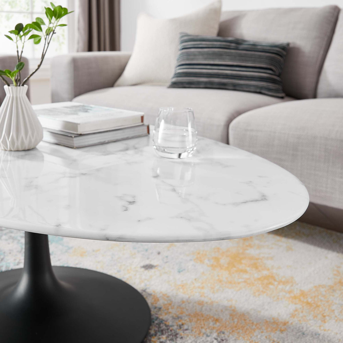 Lippa 48in oval faux marble coffee table with black pedestal base in living room on Tampa Home & Garden Store