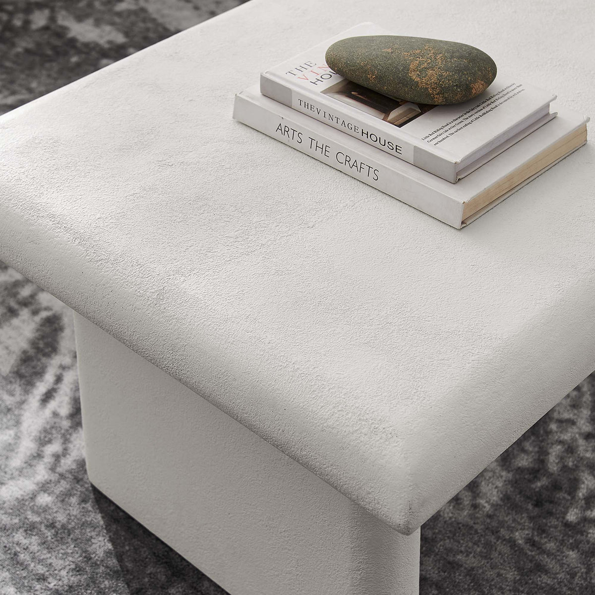 Relic Concrete Textured Coffee Table gray concrete finish with a stone atop two books on Tampa Home & Garden Store