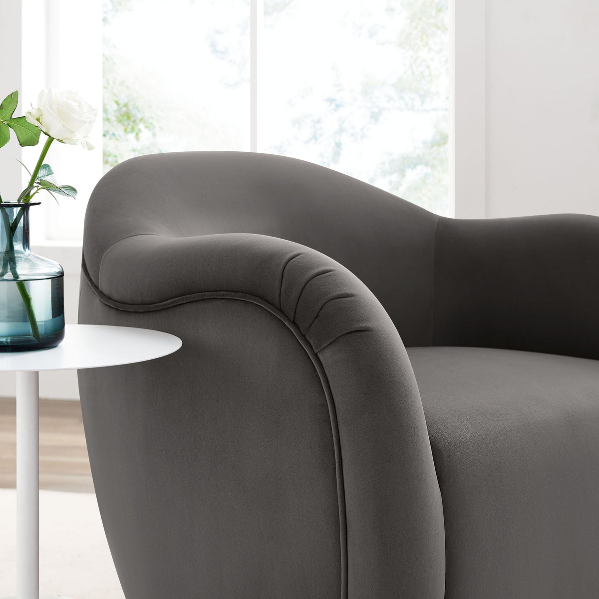Compose Performance Velvet Swivel Armchair in grey velvet with plush curves beside table on Tampa Home & Garden Store