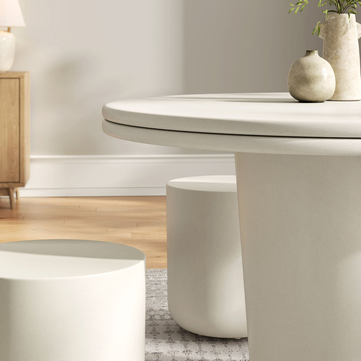 Brion concrete round dining table with thick pedestal and beige vases on tabletop on Tampa Home & Garden Store