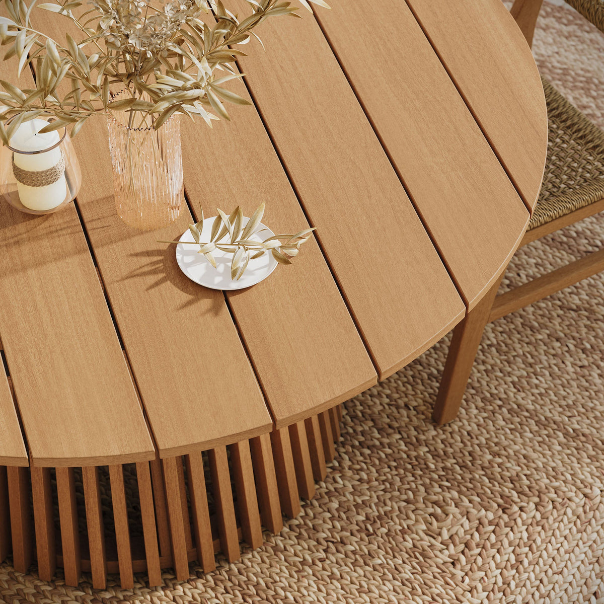 Lane Round Outdoor Teak Wood Dining Table with slatted top in warm teak finish on patio on Tampa Home & Garden Store