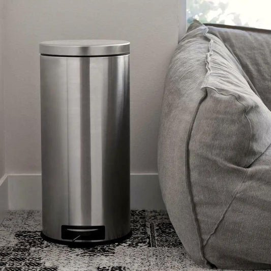 8-Gallon round stainless steel step trash can with foot pedal beside a gray sofa on Tampa Home & Garden Store