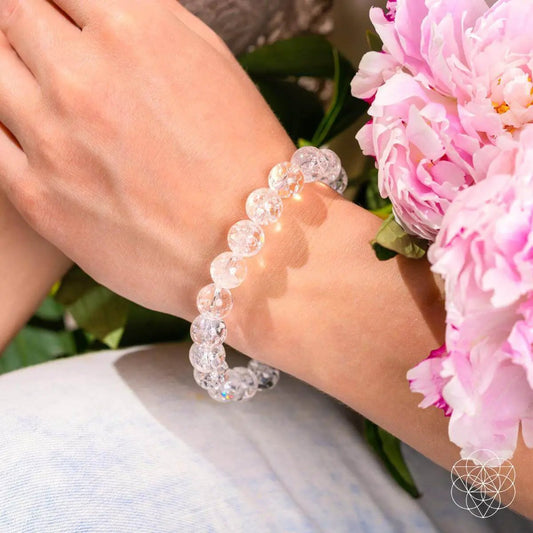 Ice Quartz Bracelet, clear crystal beads on elastic cord worn on the wrist near pink flowers on Tampa Home & Garden Store