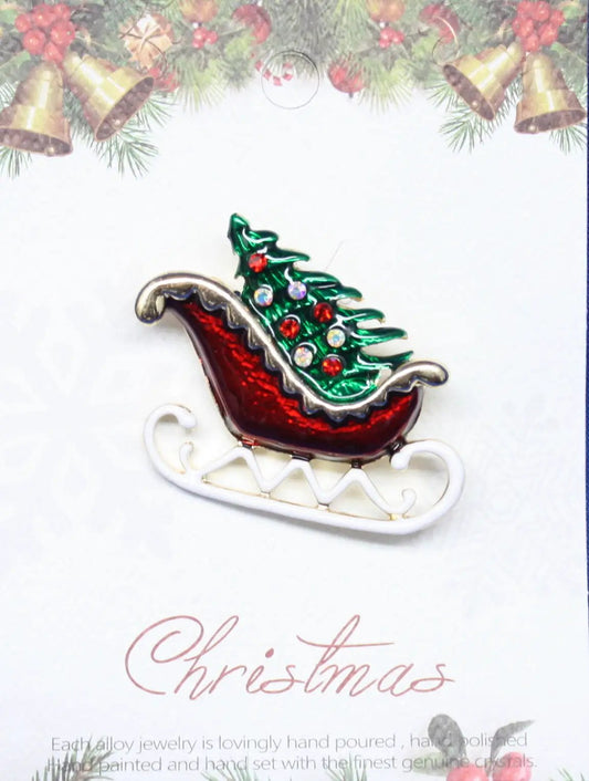 Enamel sleigh pin with green Christmas tree and colorful gems on a red sleigh on Tampa Home & Garden Store