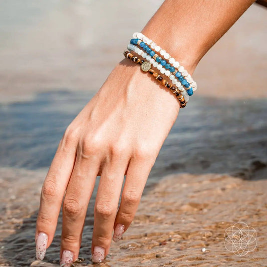 Endless Abundance bracelet pack of four on wrist with white and blue beads and gold charm on Tampa Home & Garden Store