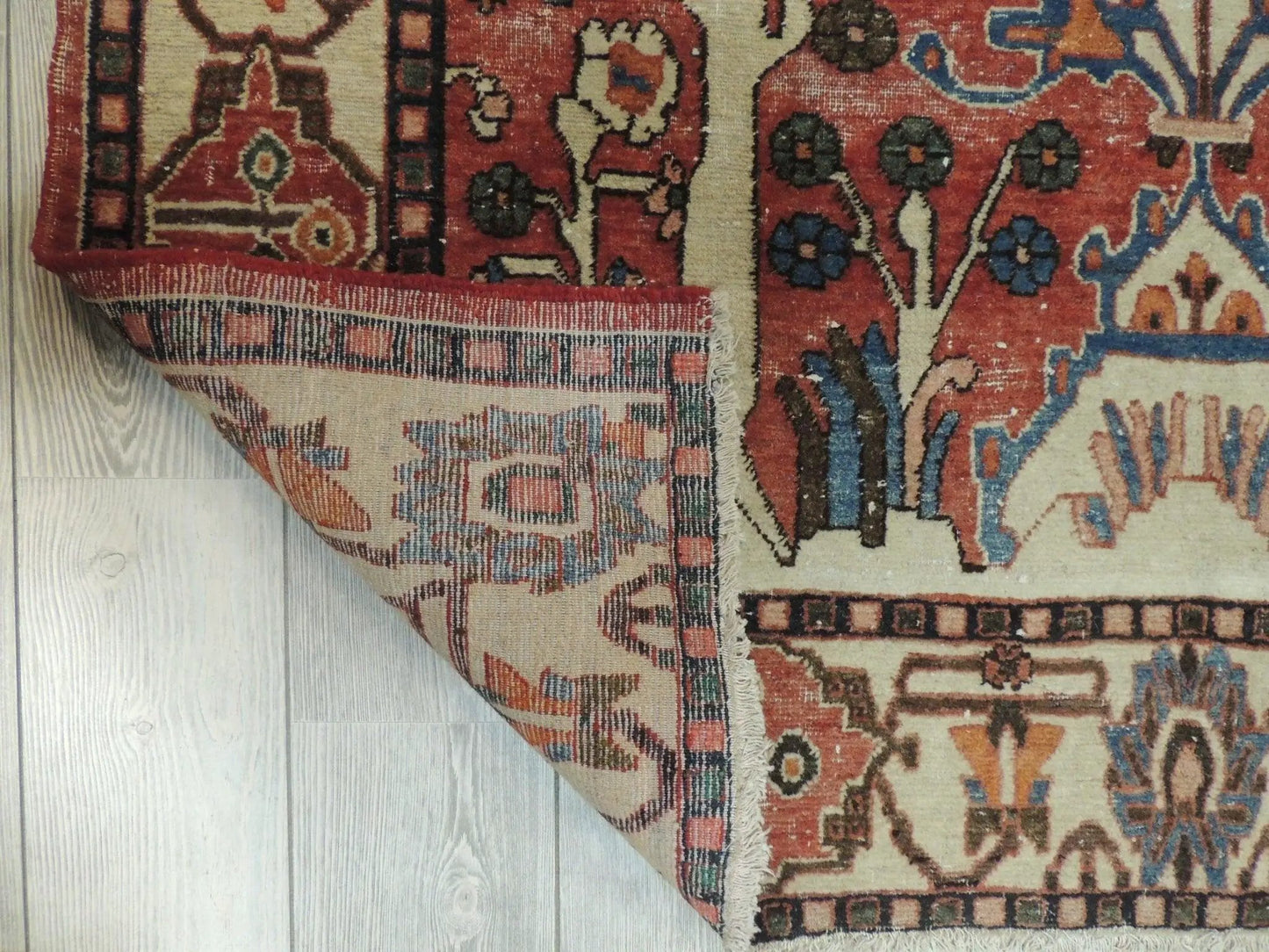 Persian Wool Rug Hand Knotted 4'9 x 6'10 red blue floral pattern with fringe on wood floor on Tampa Home & Garden Store