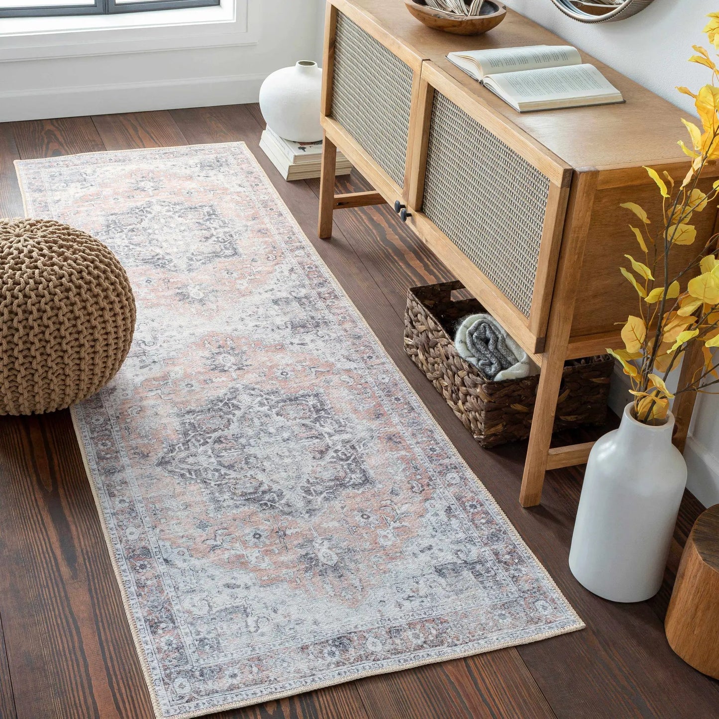 Fatih Tumble Dry Washable Rug, machine-woven blue-gray with pink accents, near a woven cabinet on Tampa Home & Garden Store
