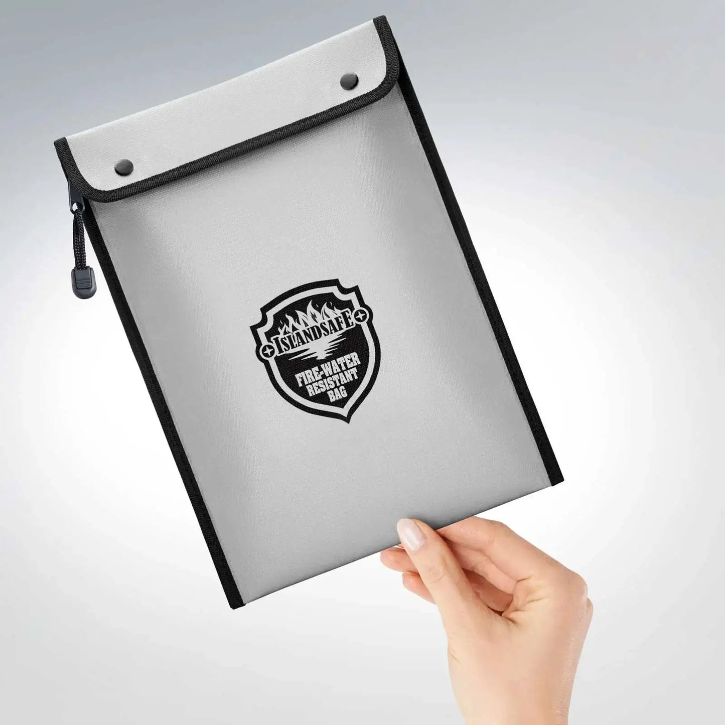 FireVault fireproof bag by ISLANDSAFE in silver-gray with black trim, held by hand on Tampa Home & Garden Store
