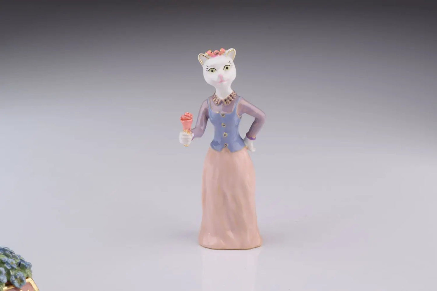 Cat figurine painted lavender blouse and peach skirt holding pink ice cream cone with crown on Tampa Home & Garden Store