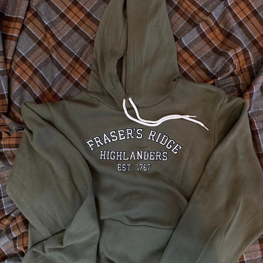 Frasers Ridge Highlanders collegiate hoodie in olive green with white drawstrings on Tampa Home & Garden Store
