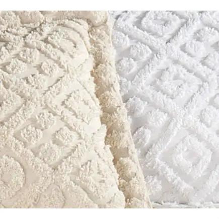 Beige chenille cotton bedspread with fringe edges beside a white quilted bedspread on Tampa Home & Garden Store