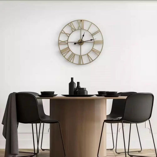 Round 24-inch gold metal wall clock with Roman numerals and black hands above a dining table on Tampa Home & Garden Store