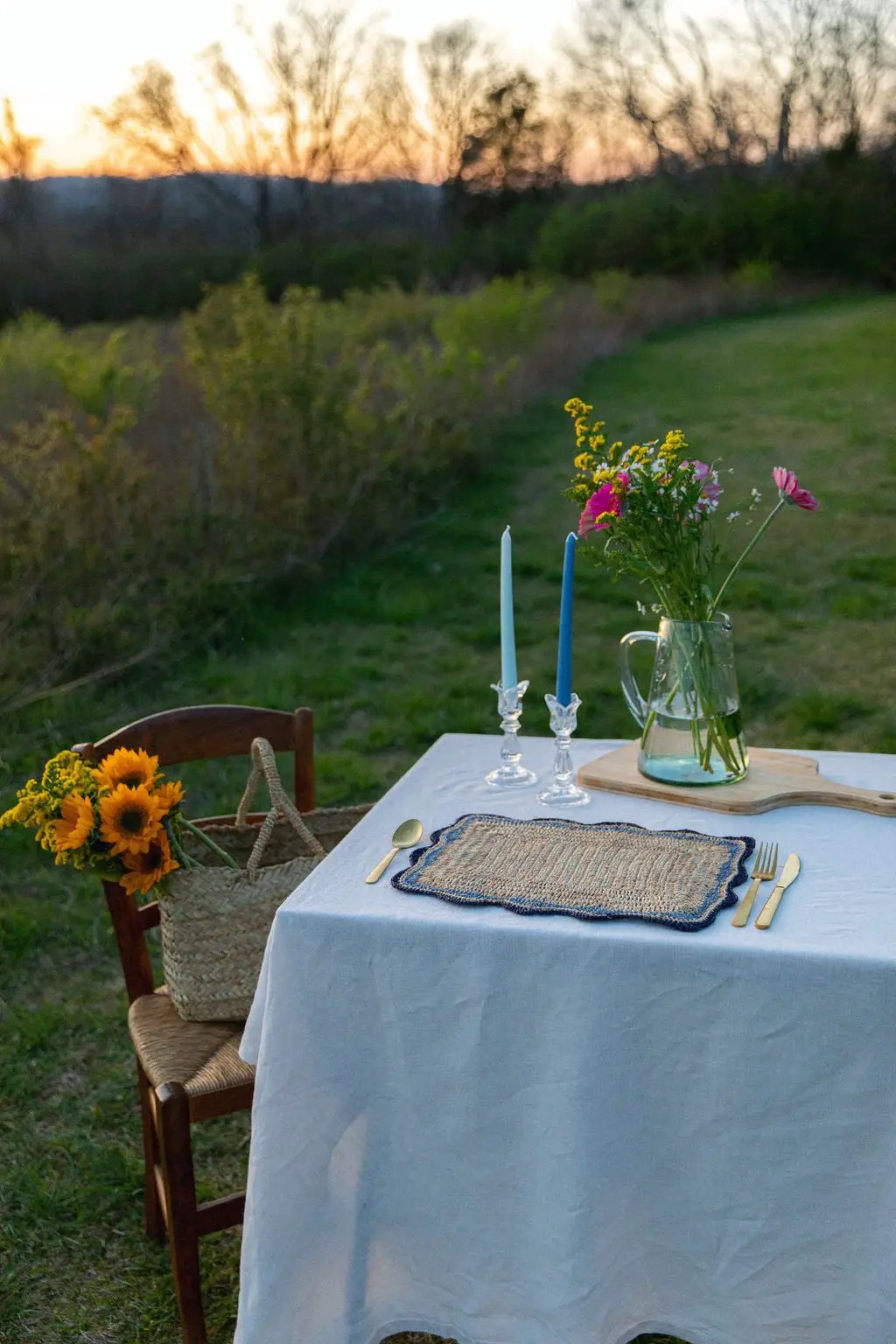 Handmade raffia placemat with blue edges on outdoor rectangular dining table by Payton James on Tampa Home & Garden Store