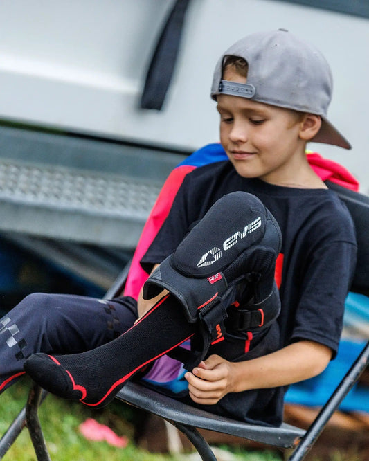Genesis Youth Knee Brace EVS Sports worn by a boy in black shirt and gray cap on Tampa Home & Garden Store