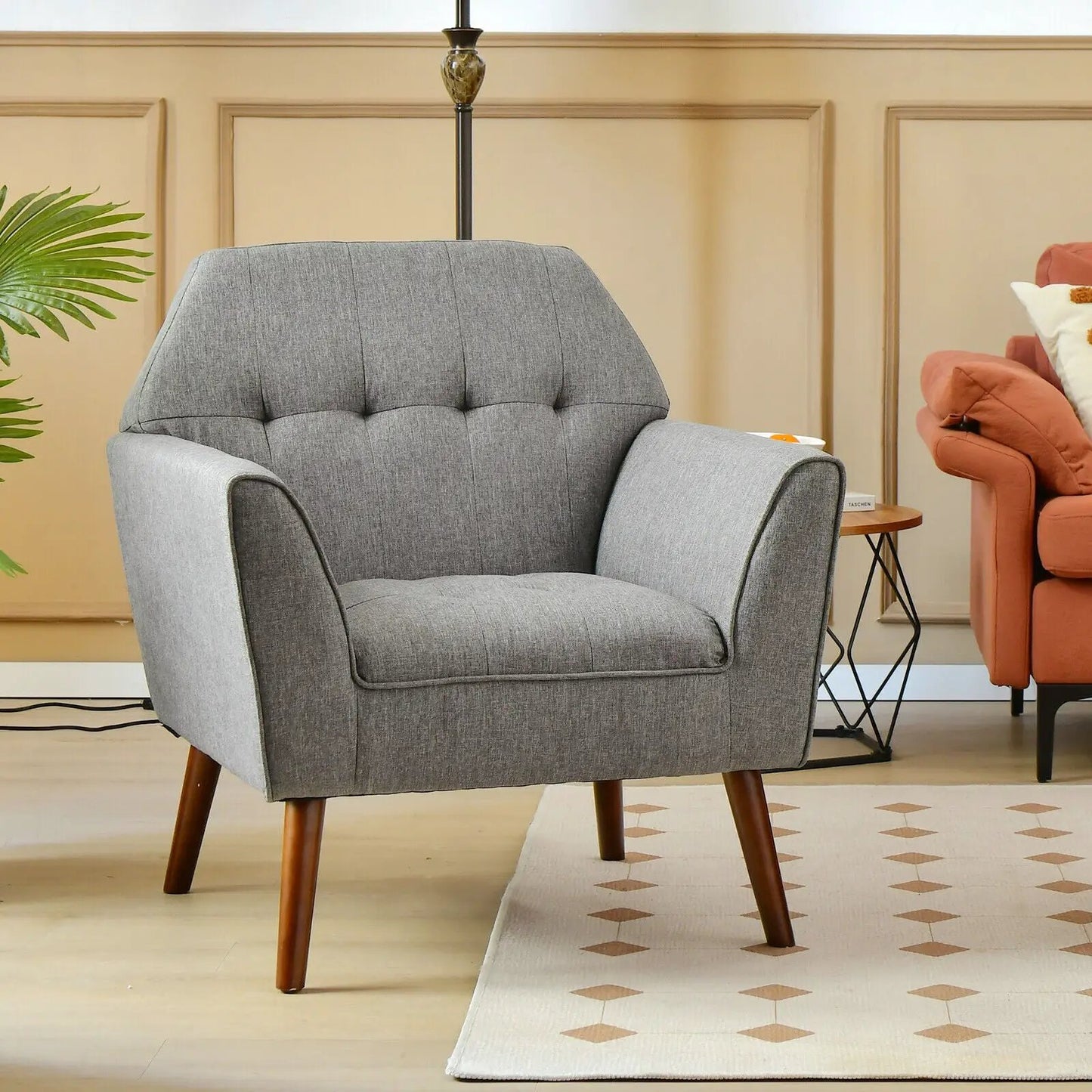 Gray tufted accent chair with wooden legs in a living room beside a chair and table on Tampa Home & Garden Store