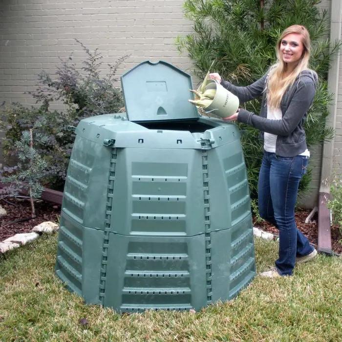 Green recycled plastic 267-gallon compost bin with open lid and person loading compost bucket on Tampa Home & Garden Store