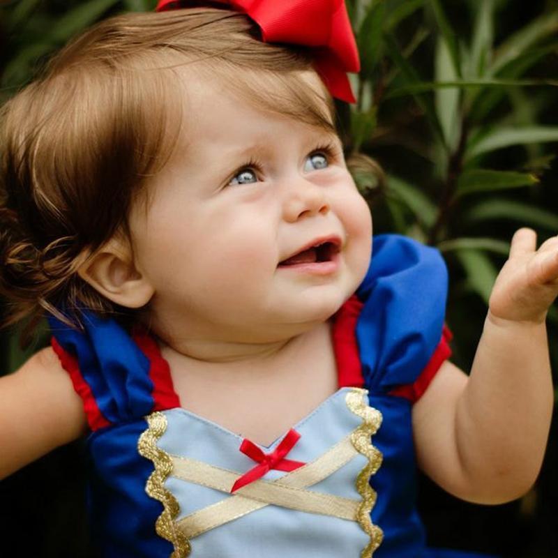 Stevvex baby dress in blue satin with gold crisscross trim and red bow accents on Tampa Home & Garden Store