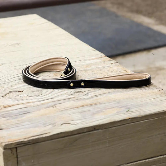 Halter Ego Black Patent Thea dog leash, black patent exterior with beige lining, coiled on wood on Tampa Home & Garden Store
