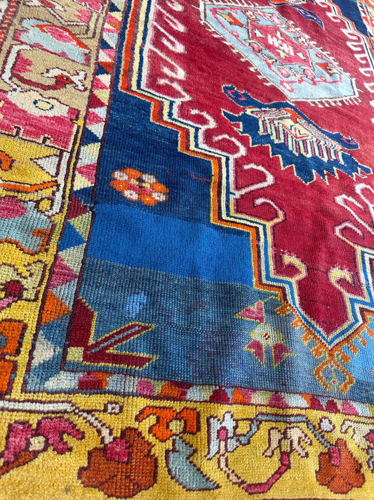 Hand-knotted antique Turkish Melas wool rug with bold red field and blue border on Tampa Home & Garden Store