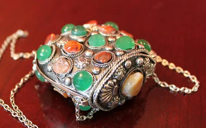 Kuchi tribal pouch pendant necklace in silver-tone metal with green and orange stones on Tampa Home & Garden Store