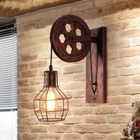 Vintage industrial pulley wall sconce with dark wood wheel and metal cage exposed bulb on Tampa Home & Garden Store