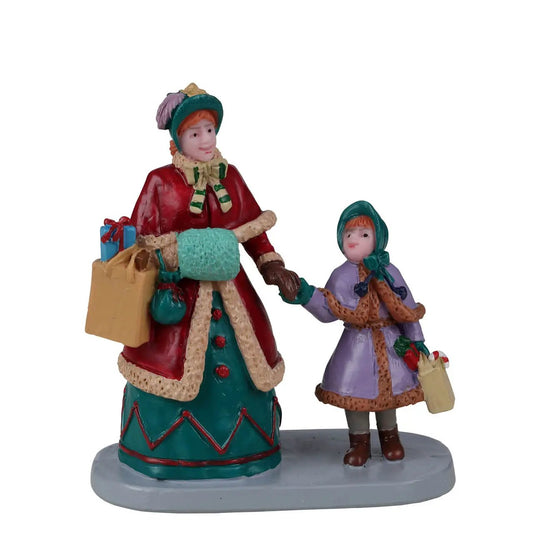 Christmas village figurines: mother in red coat and daughter in purple coat with bags on Tampa on Tampa Home & Garden Store