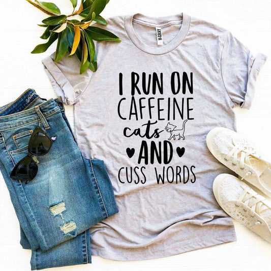 T-shirt I Run On Caffeine Cats and Cuss Words graphic tee in gray; outfit includes pair of jeans on Tampa Home & Garden Store