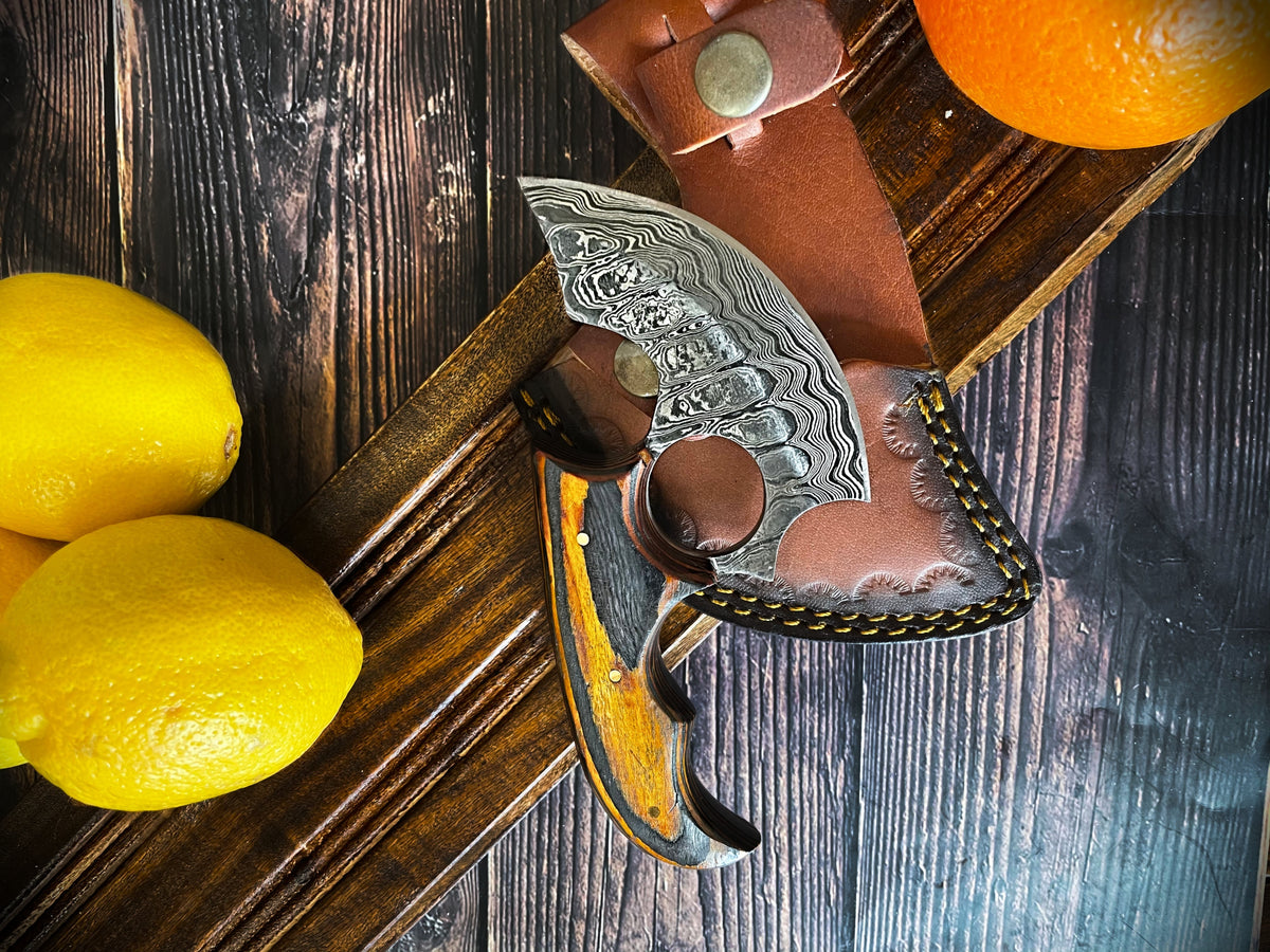 Titan Custom Alaskan Ulu Damascus knife with leather sheath on rustic wood backdrop on Tampa Home & Garden Store