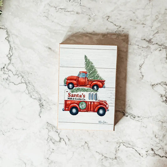 Santa's Milk & Cookies Christmas Sign by Gia Roma with red vintage trucks on white wood on Tampa Home & Garden Store
