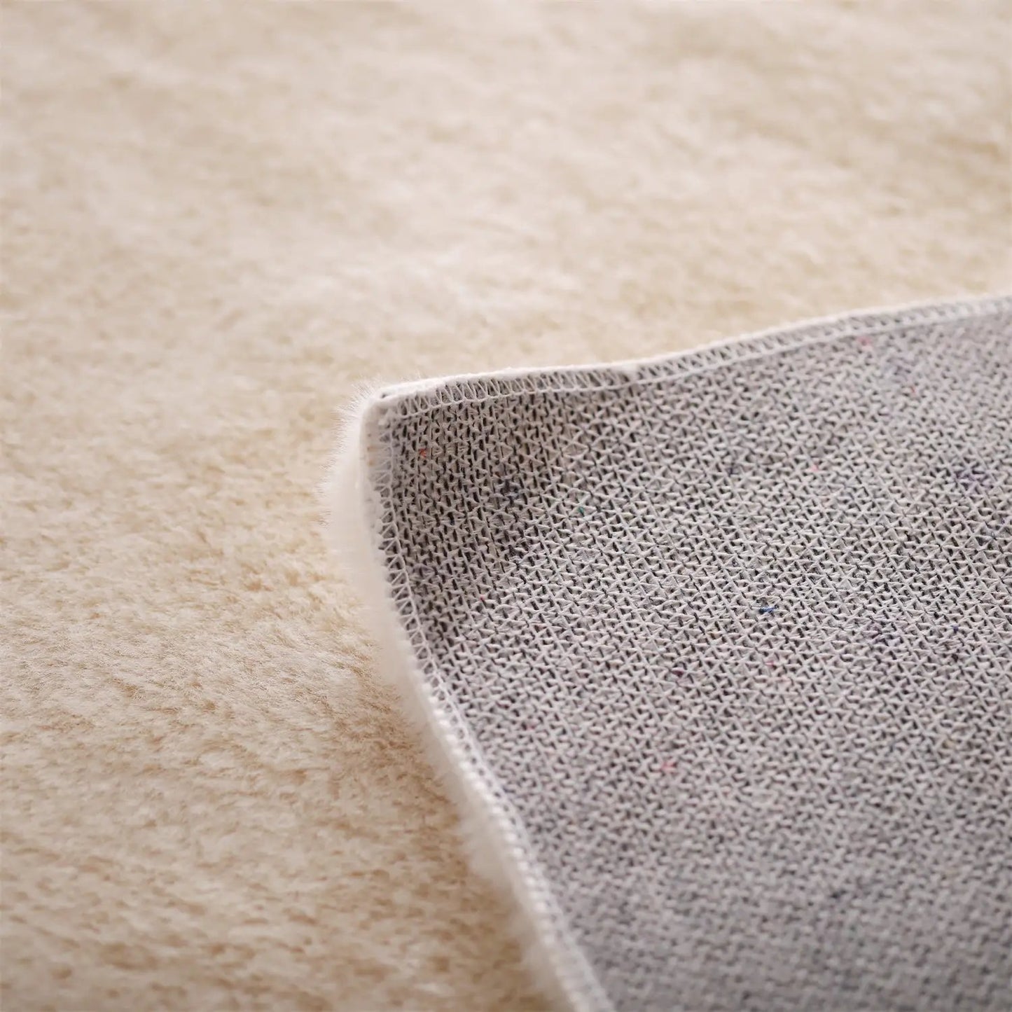 Kasentex Fluffy Faux Fur Area Rug beige top with gray woven backing, close-up edge on Tampa Home & Garden Store