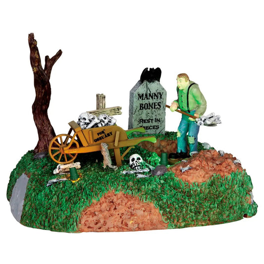 Igor the Grave Digger Figurine, green-shirted figure with shovel beside tombstone and wheelbarrow on Tampa Home & Garden Store