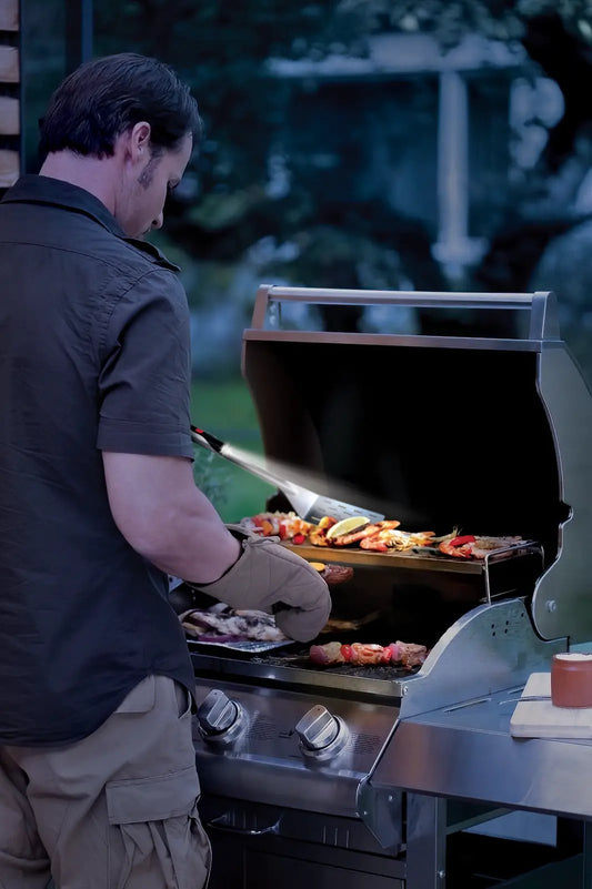 Grillight LED Spatula for night grilling on a stainless gas grill illuminating food on Tampa Home & Garden Store