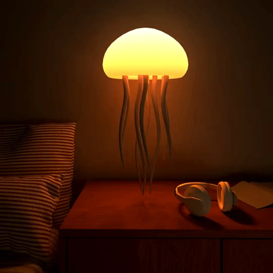 LED jellyfish lamp color-changing mood light on nightstand with warm yellow glow and headphones on Tampa Home & Garden Store