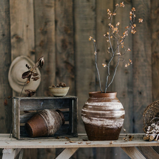 Restoration Brown Clay Pot with whitewashed stripes holds dried branches on rustic table on Tampa Home & Garden Store