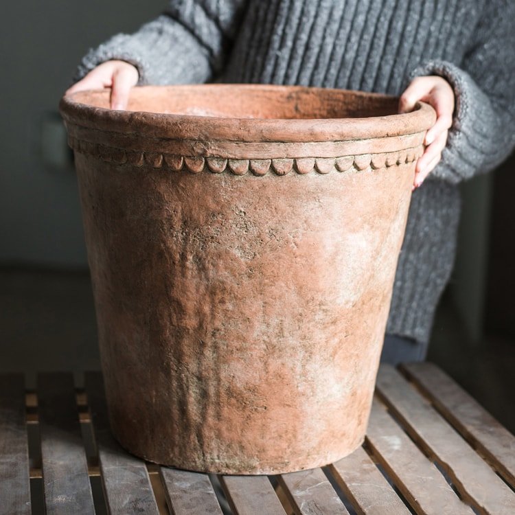 Large terracotta red concrete planter pot with beaded rim detail, weathered surface on Tampa Home & Garden Store