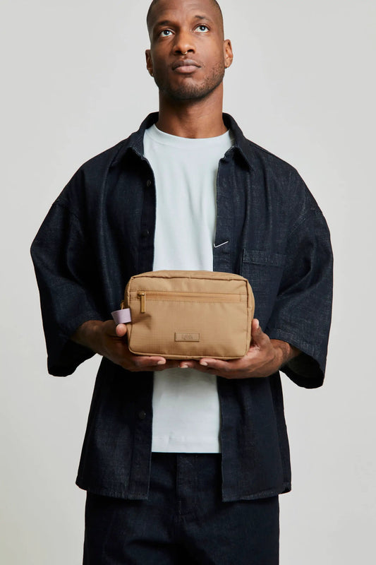 Kei Double Washbag Toffee RPET cosmetic bag tan with front zip Lefrik USA held by man on Tampa Home & Garden Store
