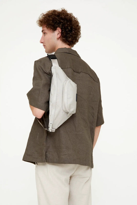 Urban Crossbody Bag with Front and Main Pockets, light gray compact nylon, worn over shoulder by man on Tampa Home & Garden Store