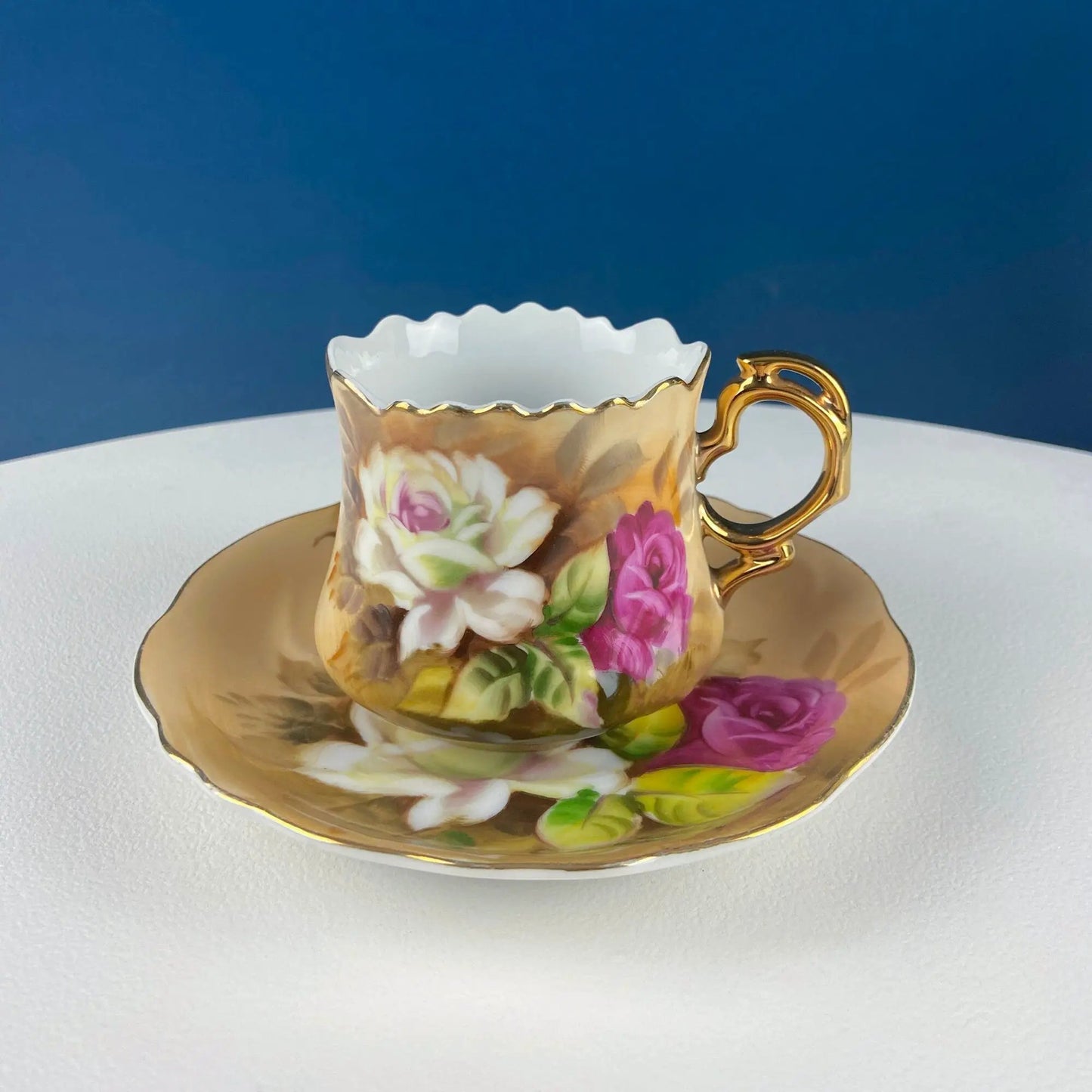 Lefton teacup and saucer with hand-painted rose motif, scalloped white rim, gold handle on Tampa Home & Garden Store