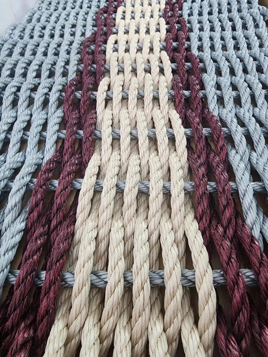 Outdoor rope rug with light gray, tan and burgundy woven strands on Tampa Home & Garden Store