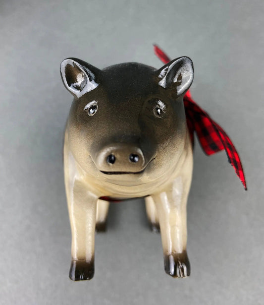 Luck Pigs figurine with brown body and black head, red plaid ribbon on Tampa Home & Garden Store