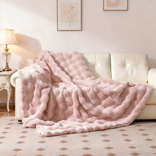Luxurious Fuzzy Rabbit Fur Bubble Blanket in soft pink, draped over a cream sofa on Tampa Home & Garden Store