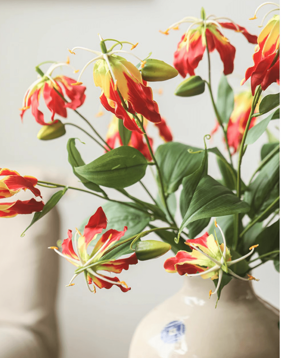Faux Fire Lily Stem by RusticReach with red petals and green leaves in a beige vase on Tampa Home & Garden Store
