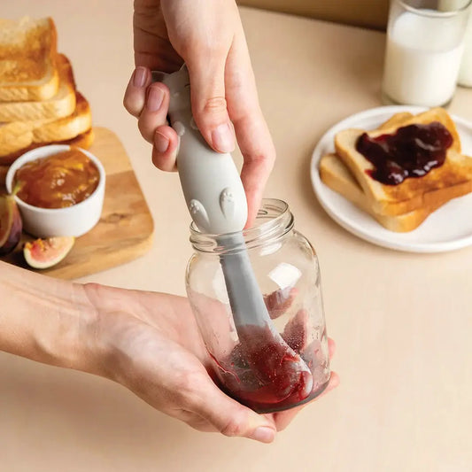 Mary Cat Jar Scraper by OTOTO DESIGN, gray silicone kitchen tool used to scoop jam from a glass jar on Tampa Home & Garden Store