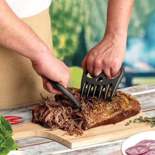 Meat Muncher Shredder Tool with black plastic handles shredding meat on cutting board on Tampa Home & Garden Store