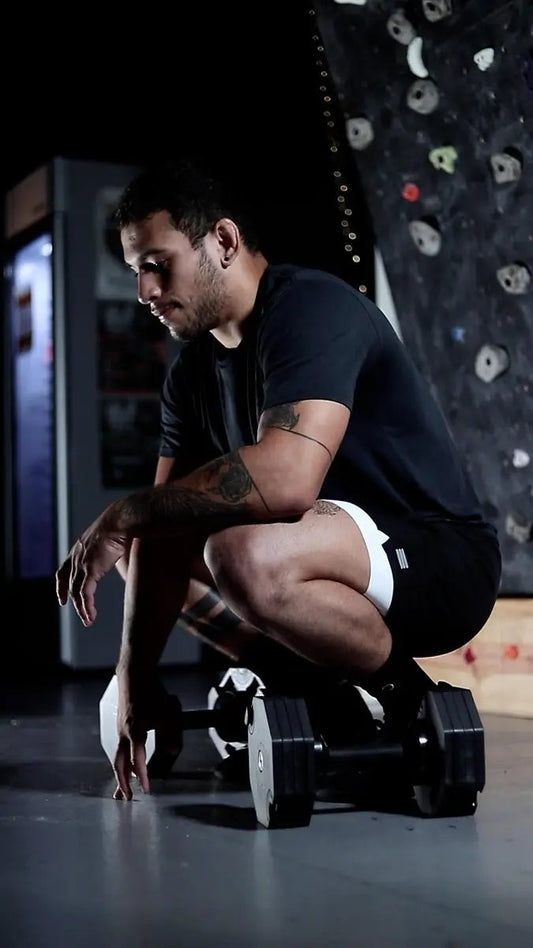 V1 Athletic Shorts by Cumulus Sport, black with white waistband, man crouching by dumbbells on Tampa Home & Garden Store